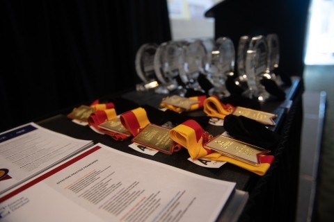 Close-up image of a banquet table with rows of USM ACUE medallions