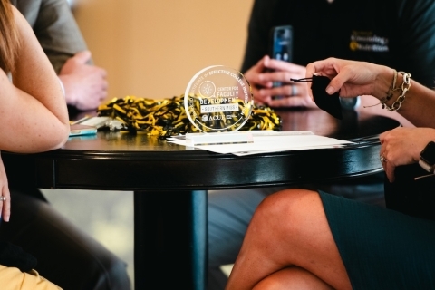 Image of a glass USM trophy for ACUE certified faculty sitting on a table